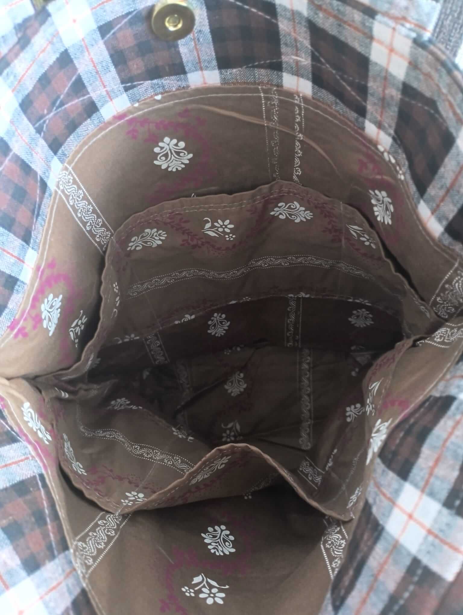 Interior view of a stylish plaid bag showcasing patterned lining and spacious compartments.