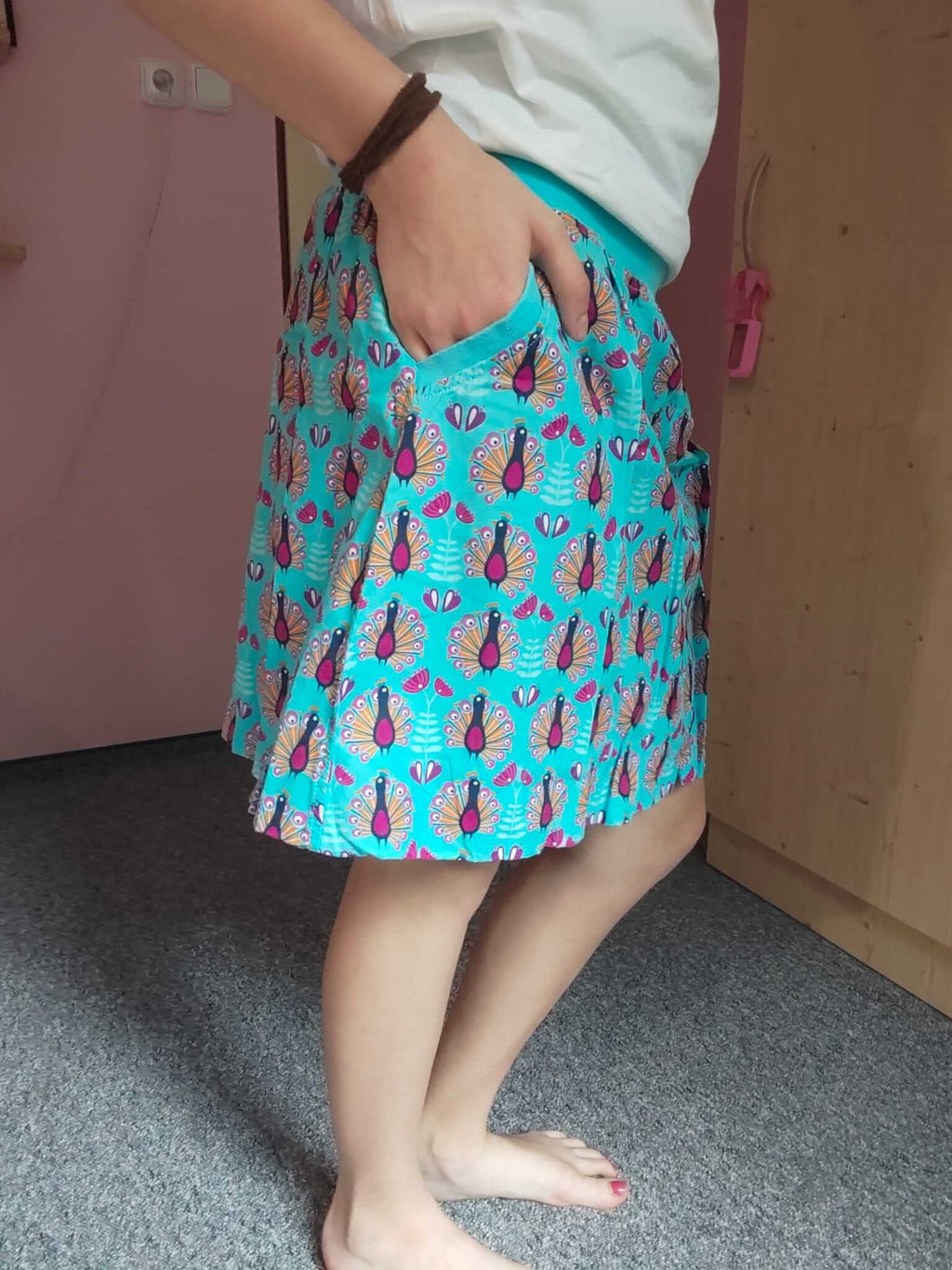 Dámská balonová sukně z bavlněného plátna v tyrkysové barvě s jedinečným vzorem pávů dodá vašemu každodennímu stylu eleganci a šarm.