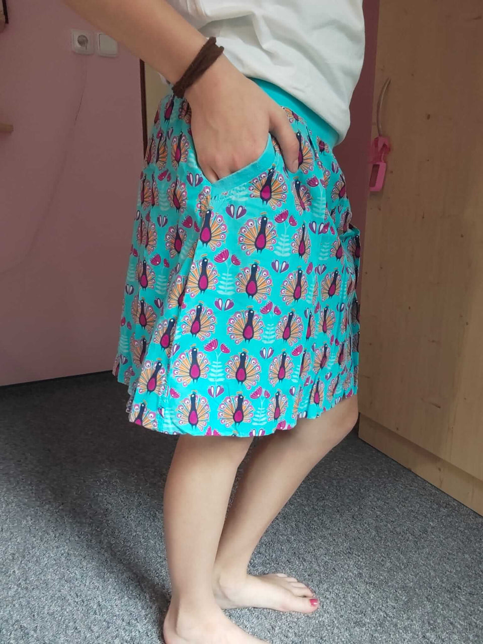Dámská balonová sukně z bavlněného plátna v tyrkysové barvě s jedinečným vzorem pávů dodá vašemu každodennímu stylu eleganci a šarm.
