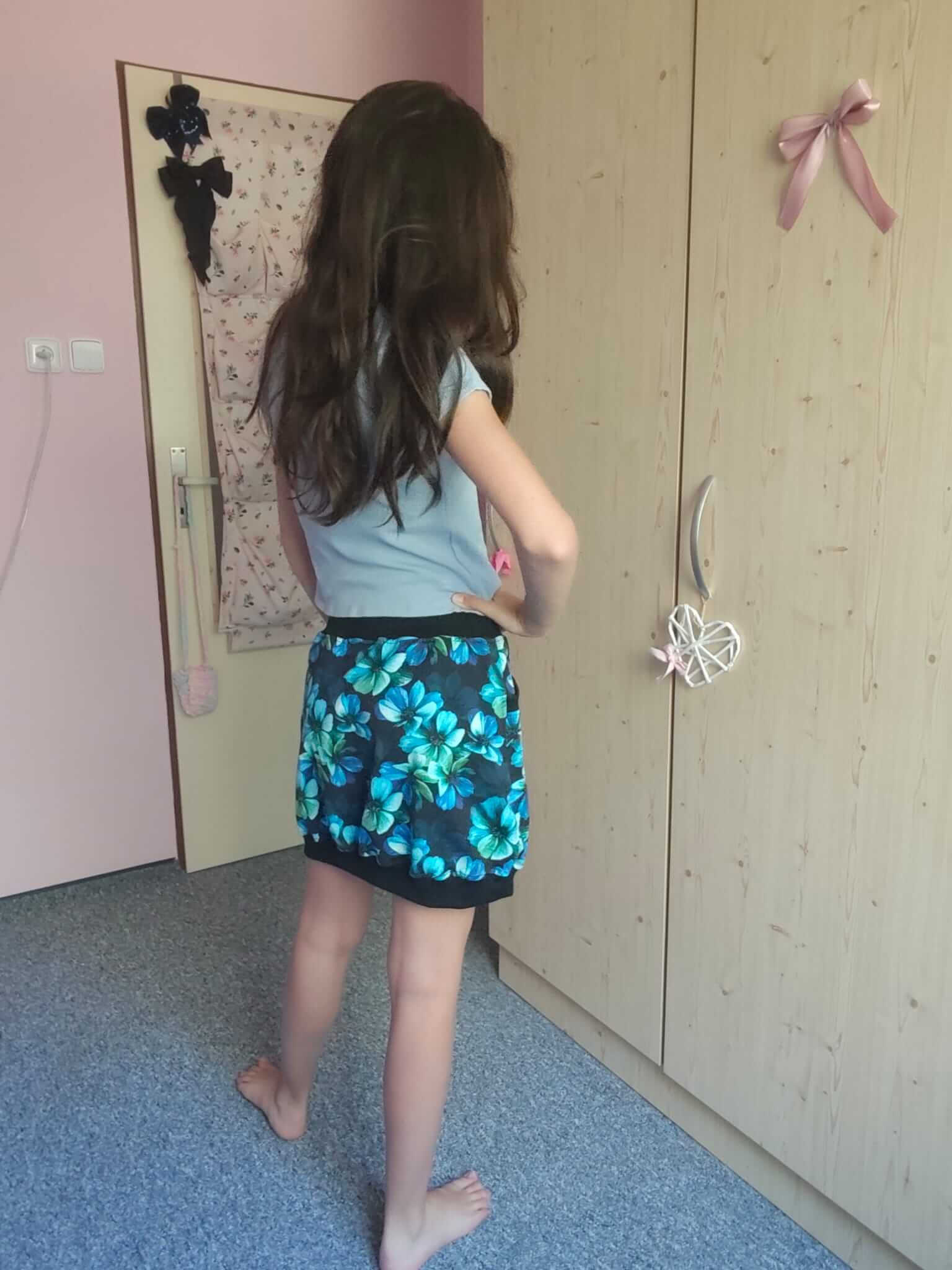 Dámská sukně z bavlněné teplákoviny s černým podkladem a modro-zelenými květy je ideální volbou pro pohodlné každodenní nošení.