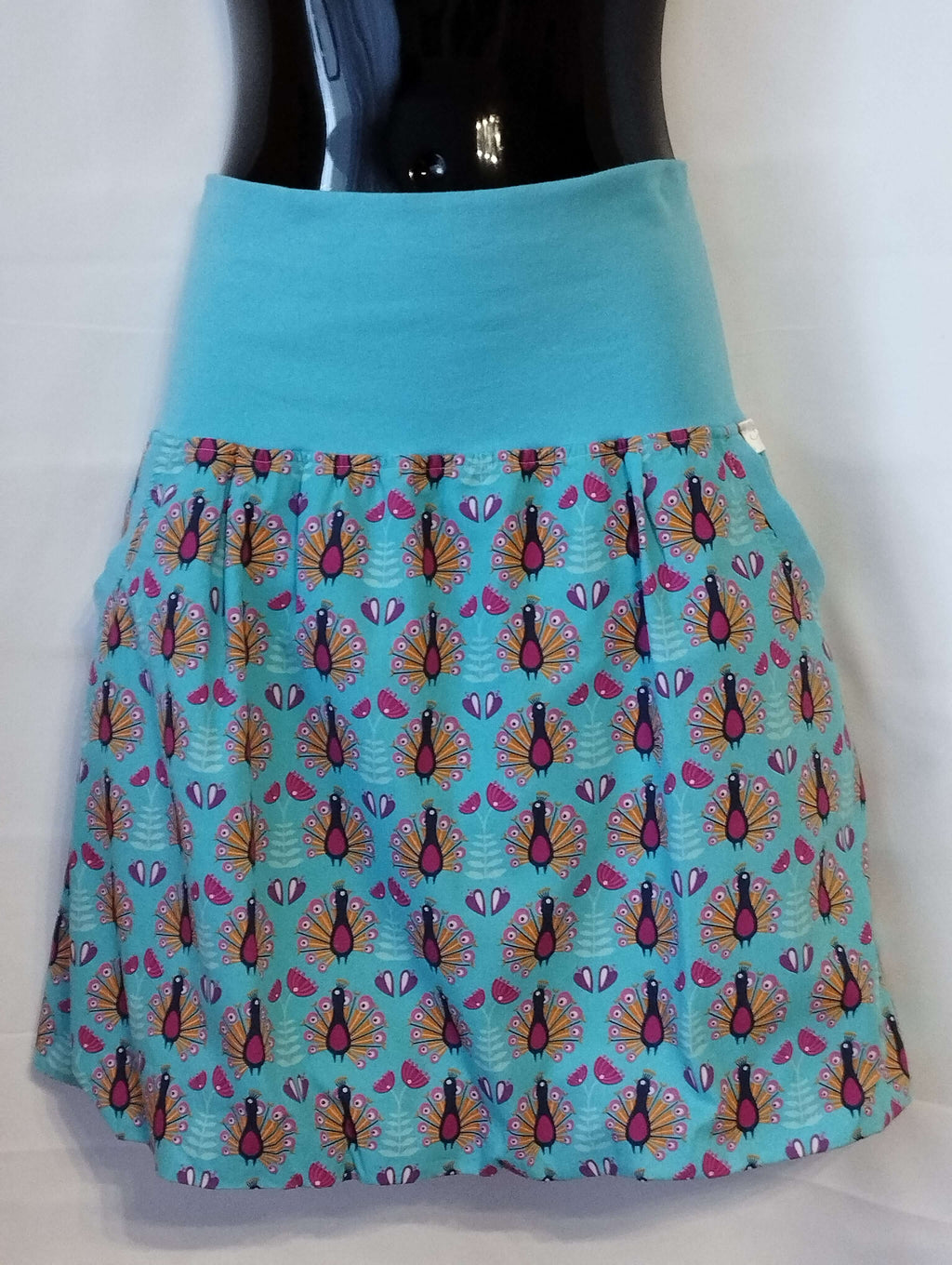 Dámská balonová sukně z bavlněného plátna v tyrkysové barvě s jedinečným vzorem pávů dodá vašemu každodennímu stylu eleganci a šarm.