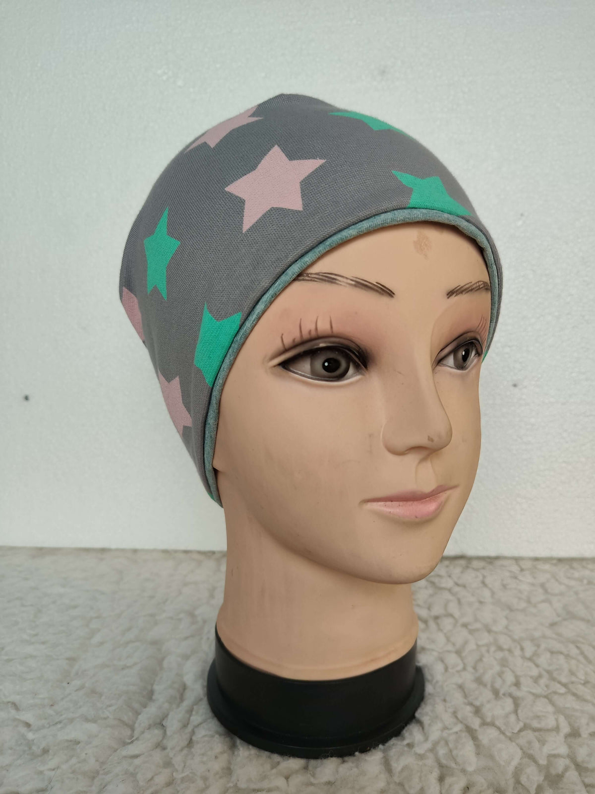 Dětská šedá úpletová čepice s hvězdami je praktickým a stylovým doplňkem pro každodenní nošení. Skvěle se hodí k různým outfitům.