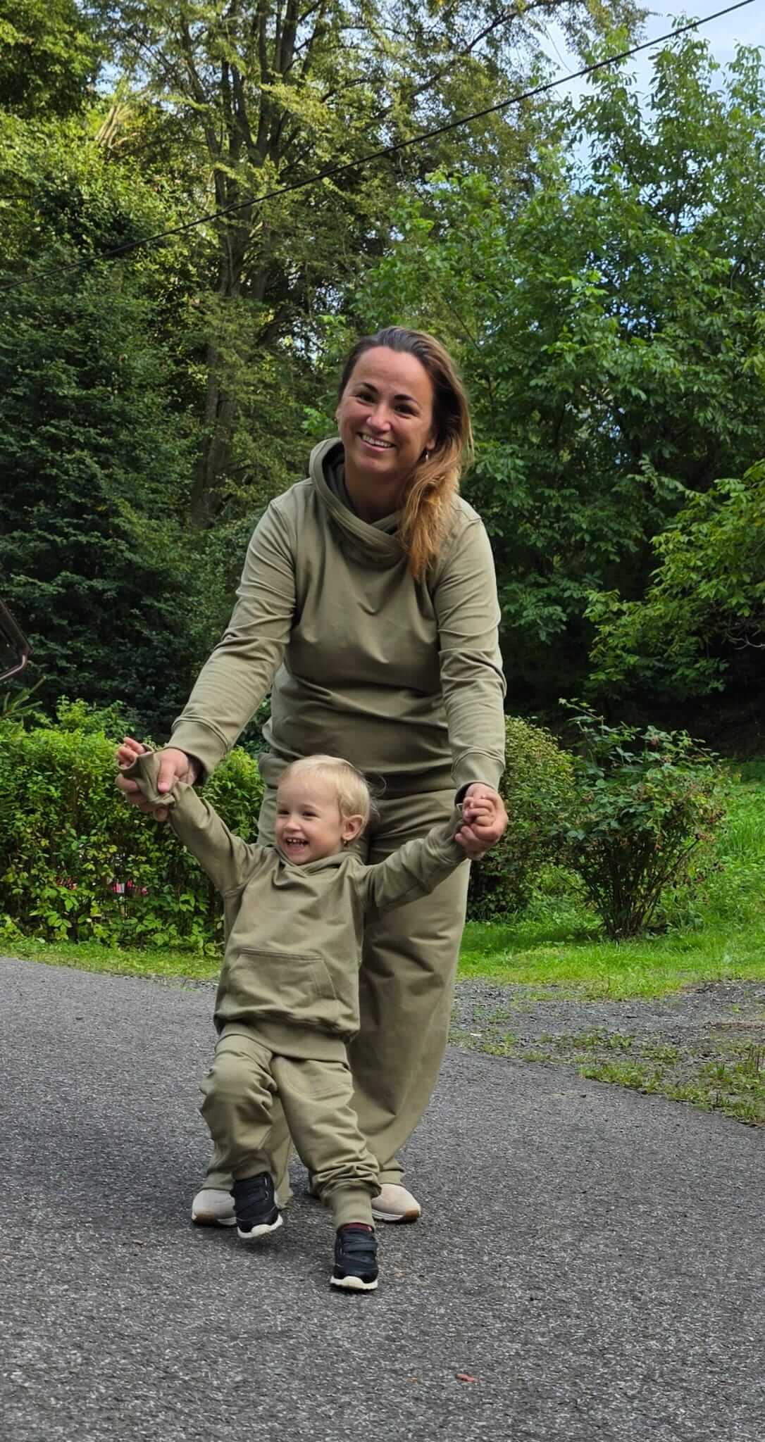 Dětská mikina s kapucí z měkké teplákoviny v khaki odstínu. Náplety na rukávech a spodním lemu, ručně šitá. Velikost 92.