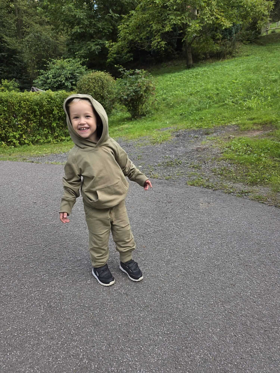 Dětská mikina s kapucí z měkké teplákoviny v khaki odstínu. Náplety na rukávech a spodním lemu, ručně šitá. Velikost 92.