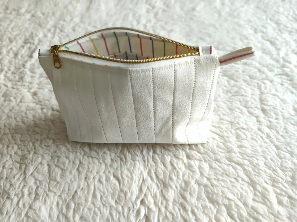 Elegantní Bílá kosmetická taštička z koženky s prošíváním je perfektní pro vaše kosmetické potřeby a osobní drobnosti. Zamilujte se do její jemné elegance!